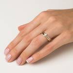 złoty pierścionek z brylantem na palcu - ręka z pierścionkiem