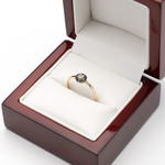 Złoty pierścionek z szafirami i brylantami w ozdobnym pudełku.